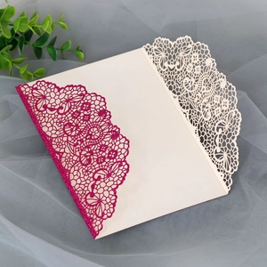 Detail of laser-cut lace invitation with pink glitter and gold hollow patterns