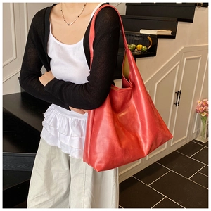 Stylish red large-capacity leather tote bag worn over the shoulder for commute look