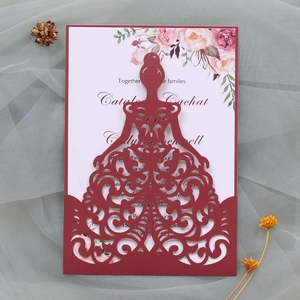 Macro detail of laser-cut burgundy wedding card with elegant bridal gown outline