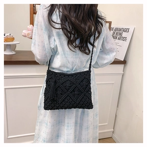 Detail of black macrame crossbody bag featuring bohemian weave and fringe tassels