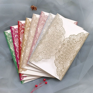 Detail of laser-cut hollow lace wedding invitations with glitter finish in multiple colors