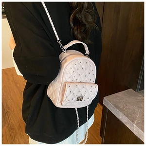 Detail of light pink quilted mini backpack with rhinestone studs and chain strap