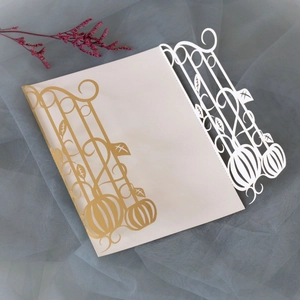 Detail of laser-cut pumpkin invitation card featuring intricate vine and fence patterns