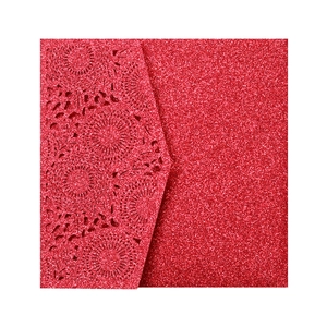 Détails de motifs floraux découpés au laser sur papier rouge pailleté pour faire-part
