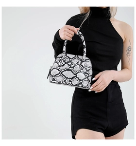 Detail of a chic black and white python print shell handbag with sleek zipper hardware
