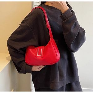 Detail of red lychee leather hobo bag with silver buckle worn by a model