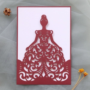 Intricate laser-cut wedding invitation featuring a burgundy dress silhouette and scrollwork