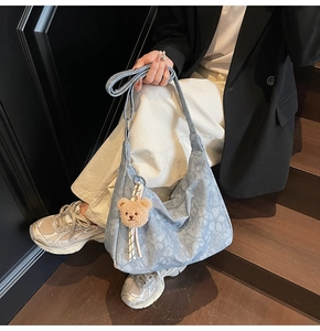 Hobo-Tasche aus Denim mit Blumenmuster und Bärenanhänger im modischen Streetstyle