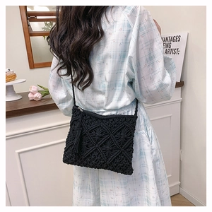 Détail d'un sac bandoulière noir tissé à la main avec franges et texture en losange