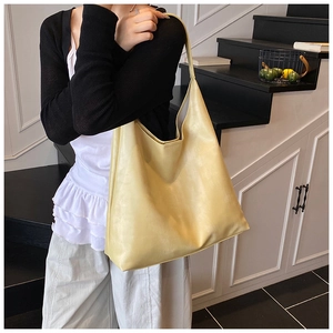 Detail of soft yellow PU leather tote bag shown on model with long shoulder strap