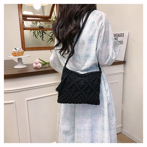 Detail of black macrame shoulder bag showing diamond texture and stylish side tassels