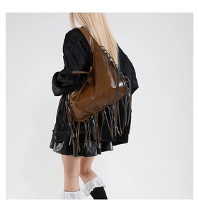 Detail of dark brown leather hobo bag featuring side lacing and long stylish tassels