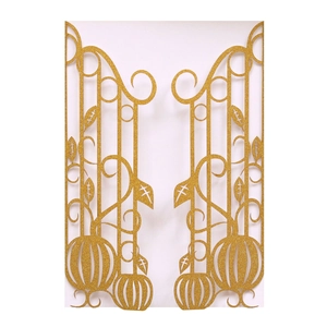 Close-up of laser-cut gold glitter invitation cover with pumpkin and scrollwork patterns