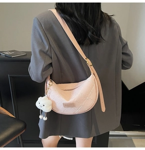 Detail of pink crescent bag with floral texture and cute cloud charm on shoulder