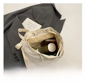 Detailed interior view of a white canvas drawstring backpack with large storage capacity