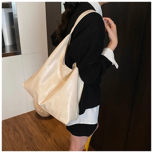 Side view of an ivory tote bag on a model showing high-quality synthetic leather detail