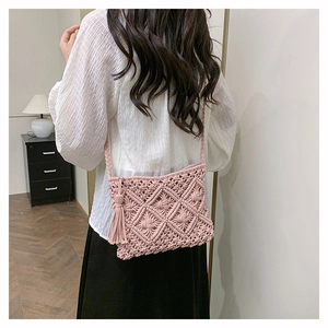 Detail of pink hand-woven macrame crossbody bag with long tassels and diamond texture