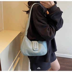 Detail of light blue pebble leather hobo bag with a rectangular silver buckle