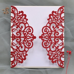 Detailed laser-cut red glitter wedding invitation cover with intricate hollow vine patterns