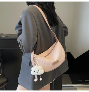 Detail of pink crescent bag with embossed texture and fluffy white cloud charm
