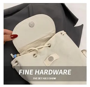 Nahaufnahme der magnetischen Metallschnalle und des Kordelzugs am weißen Nylon-Rucksack