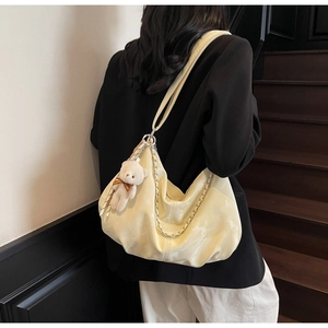 Détail d'un sac cabas jaune en cuir PU avec chaîne en métal et breloque ours en peluche