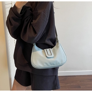 Detail view of the light blue lychee pattern leather and silver buckle on the shoulder bag