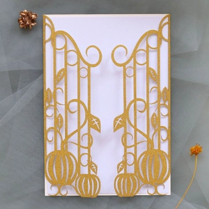 Macro detail of laser-cut glitter gold pumpkin invitation cover with intricate vine patterns