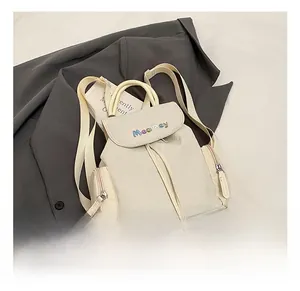 Close-up of beige nylon backpack with MeaRey embroidery and drawstring detail