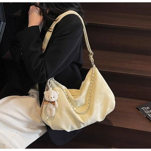 Détail du sac hobo en cuir PU crème avec chaîne argentée et breloque ours en peluche