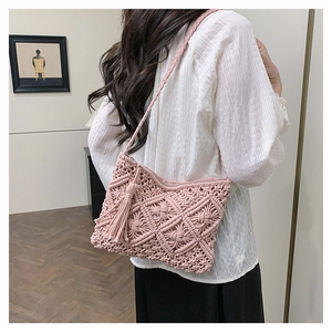 Détail du sac tissé bohème rose avec pompons faits main et texture de crochet fin