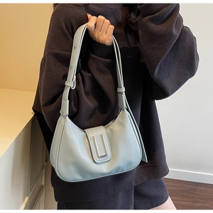 Detail of light blue hobo bag showing litchi grain leather texture and U-shaped metal buckle