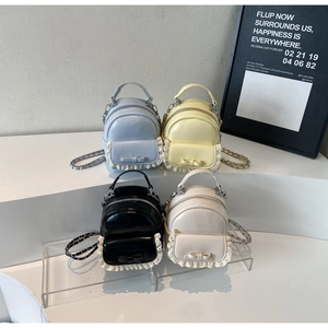 Row of mini bow-knot backpacks in shiny patent leather with lace trim and chain straps