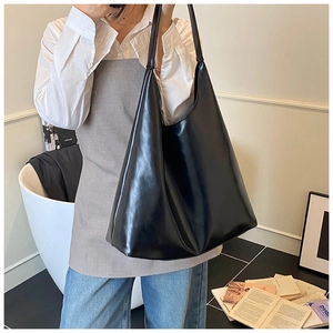 Detail of black leather tote bag with soft glossy finish and spacious open interior