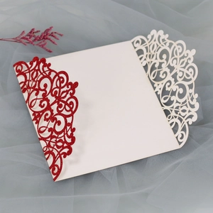 Detailed laser-cut vine patterns on a red and white glitter wedding invitation cover