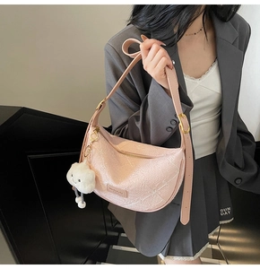 Pink hobo bag detail with floral embroidery texture and white cloud plush charm