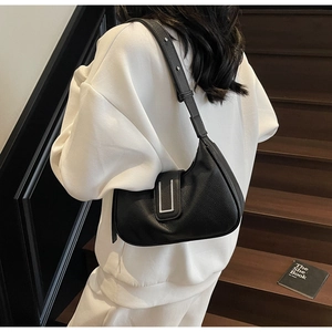 Detail of black lychee grain leather crescent bag with silver metallic buckle