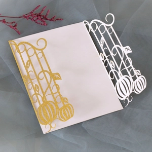 Detail of laser-cut pumpkin invitation with gold glitter and white paper insert