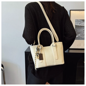 Vue détaillée du sac cabas crème texture crocodile avec chaîne en résine et breloque chocolat