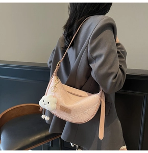 Pink crescent crossbody bag with embossed plant texture and white cloud plush charm