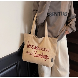Detail of beige canvas tote bag with red embroidered slogan less Mondays more Sundays
