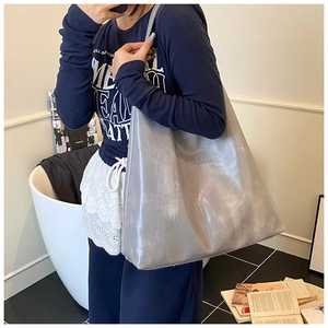 Silver grey metallic tote bag with natural pleated texture shown on model's shoulder