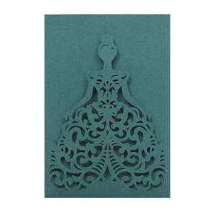 Macro detail of laser cut intricate lace pattern on a dark teal wedding invitation card