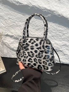 Fashionable leopard print shell bag in glossy patent leather with adjustable shoulder strap