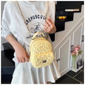 Detail of light yellow quilted mini backpack with rhinestones and metal chain strap