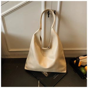 Chic cream tote bag detail showing the soft leather texture and wide shoulder strap
