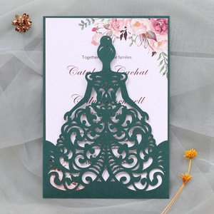 Close-up of laser-cut wedding invitation with dark green floral dress design and floral insert