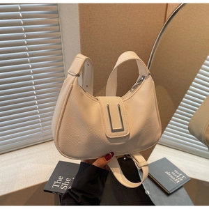 Detail of cream pebbled leather hobo bag with U-shaped silver metal hardware decoration