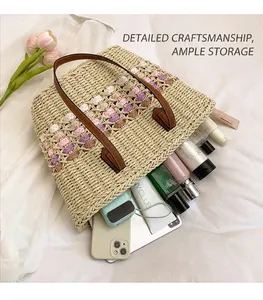 Vue détaillée d'un grand sac cabas en paille tressée contenant tablette et cosmétiques