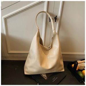 Detail view of large cream hobo tote bag with wide strap and smooth faux leather finish